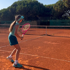 Joven jugadora en tierra batida con la raqueta junior rosa de myRacket