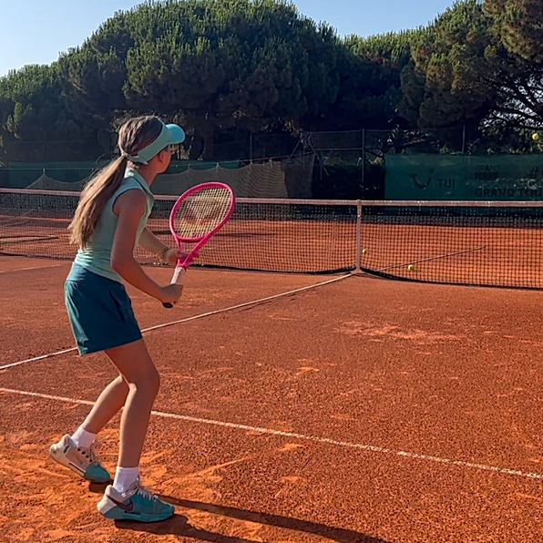 Joven jugadora en tierra batida con la raqueta junior rosa de myRacket