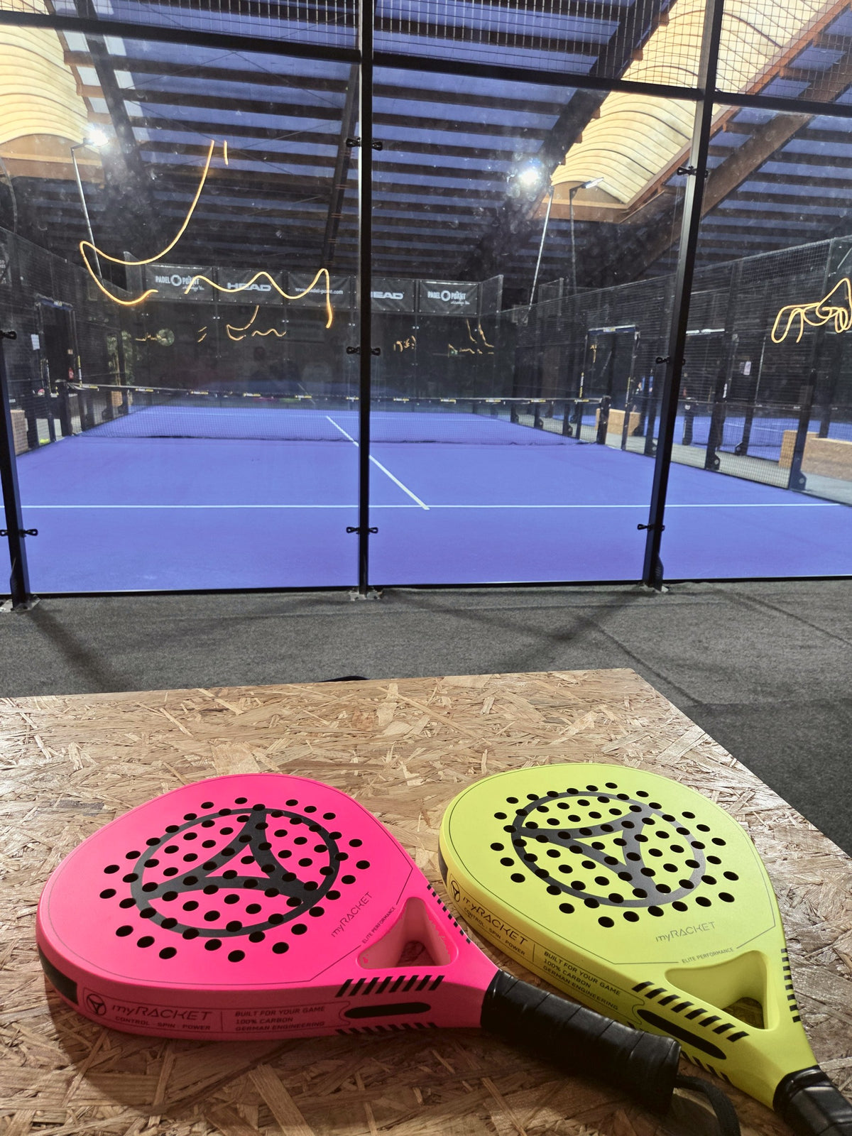 myRacket Padelschläger in Pink und Gelb auf dem Padel-Court