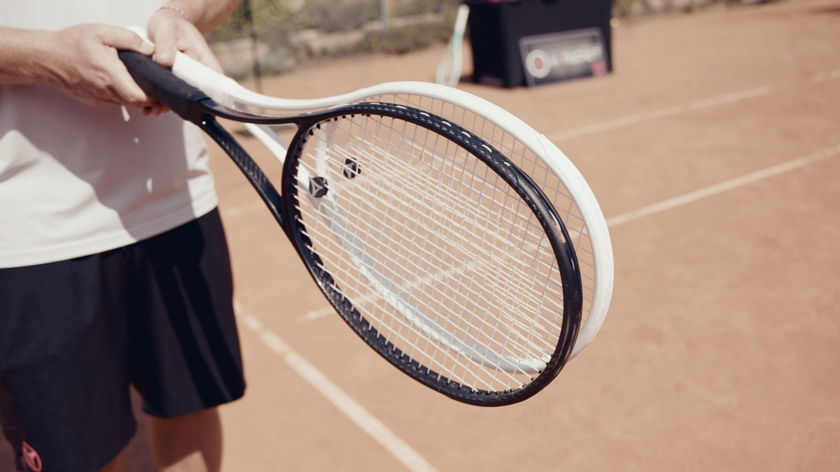 Zwei Tennisschläger im Vergleich auf dem Sandplatz