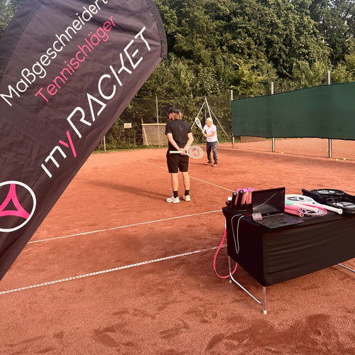 myRacket-Beachflag beim Fittingday im Verein, dahinter Fitter und Spieler beim Testen