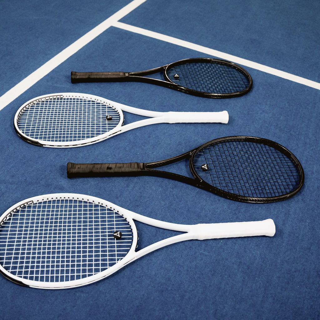 Čtyři rakety myRacket v černé a bílé na modrém tvrdém kurtu