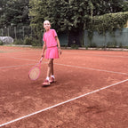 Joven jugadora vestida de rosa con su raqueta junior myRacket en tierra batida